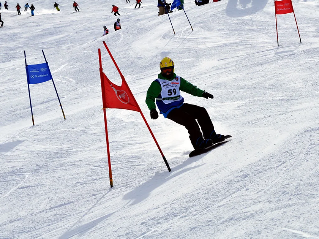 Snowboarder mit gelber Mütze und Startnummer 59 am Tor.